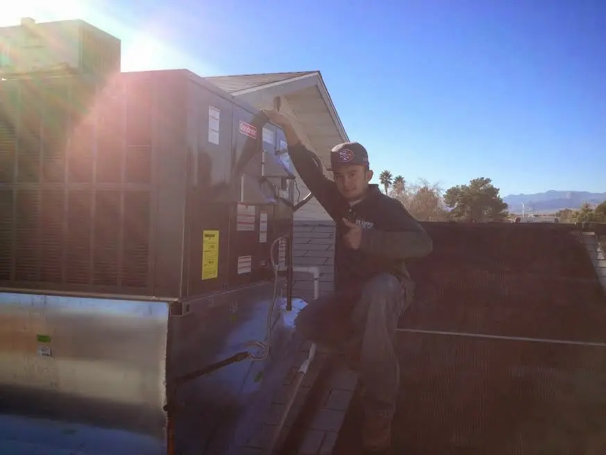 HVAC technician performing Boiler Repair on a rooftop unit in Clarksdale